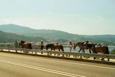 Horseback riders crossing the Miño River bridge from Spain into Portugal