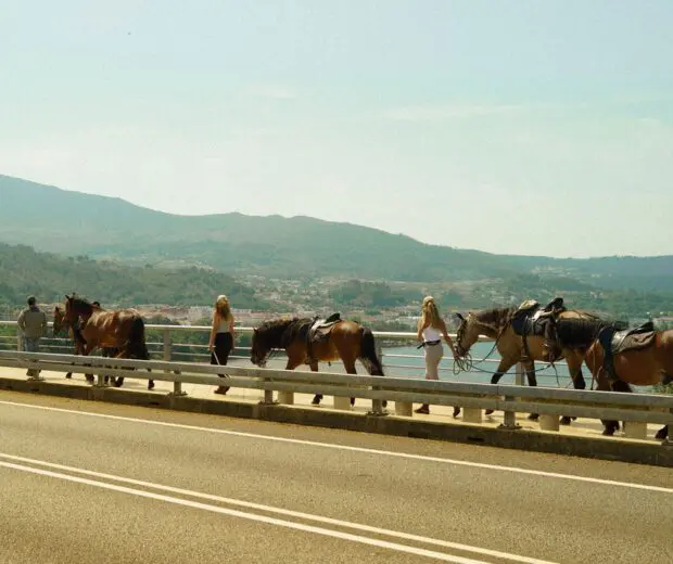 Horseback riders crossing the Miño River bridge from Spain into Portugal