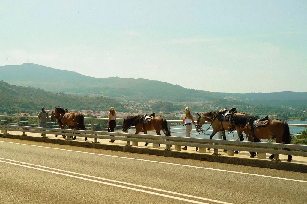 Horseback riders crossing the Miño River bridge from Spain into Portugal