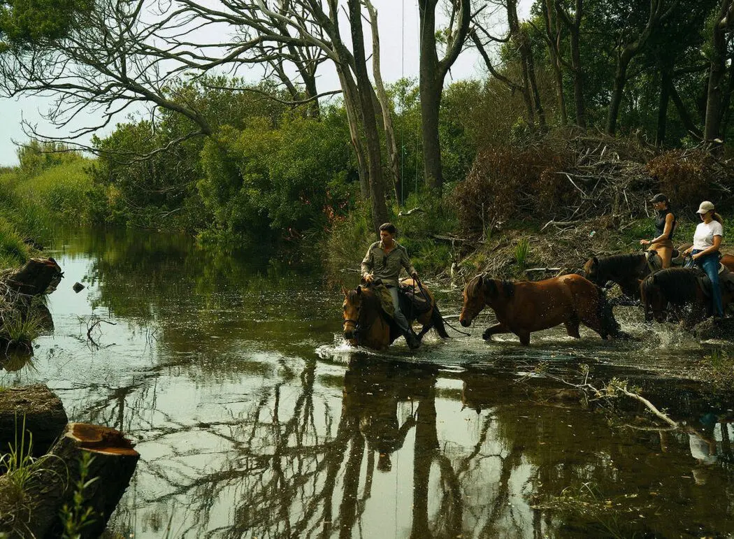 Riders fording a river on the Smuggler's Trail in Galicia