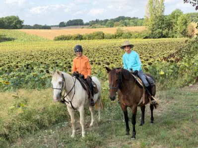 Friends on horseback enjoying sunflowers in southwest France